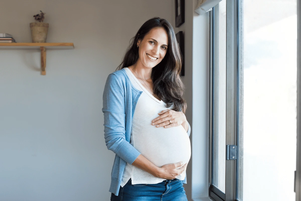 a pregnant woman smiling at home
