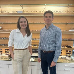 Dr. Higley and Dr. Rice standing in front of eyeglasses and sunglasses at New England Eyeworks in Keene, NH